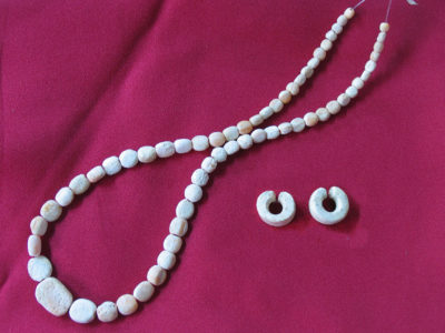 Fig. 5 Monili di conchiglia tridacna databili alla tarda Età del bronzo: collana di 65 perle dal corredo della Tomba 13 in NT3 e coppia di orecchini dalla Tomba 6 in NT2.
